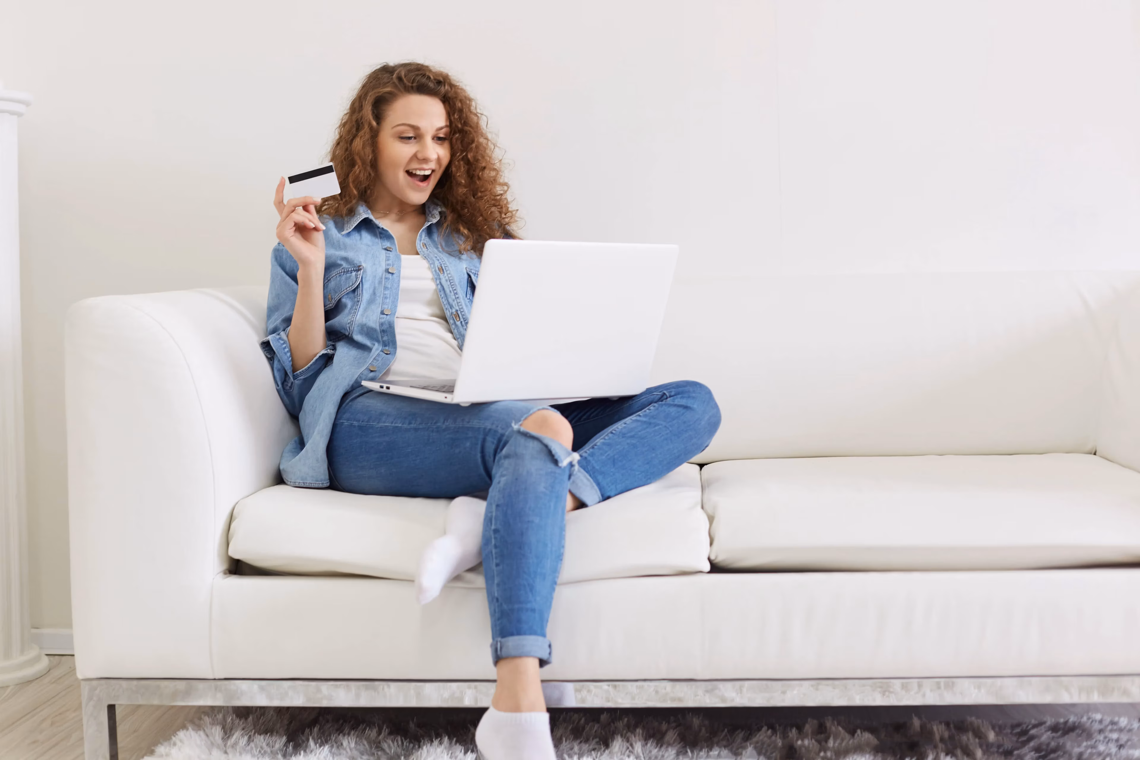 Woman shopping online with a credit card and laptop.