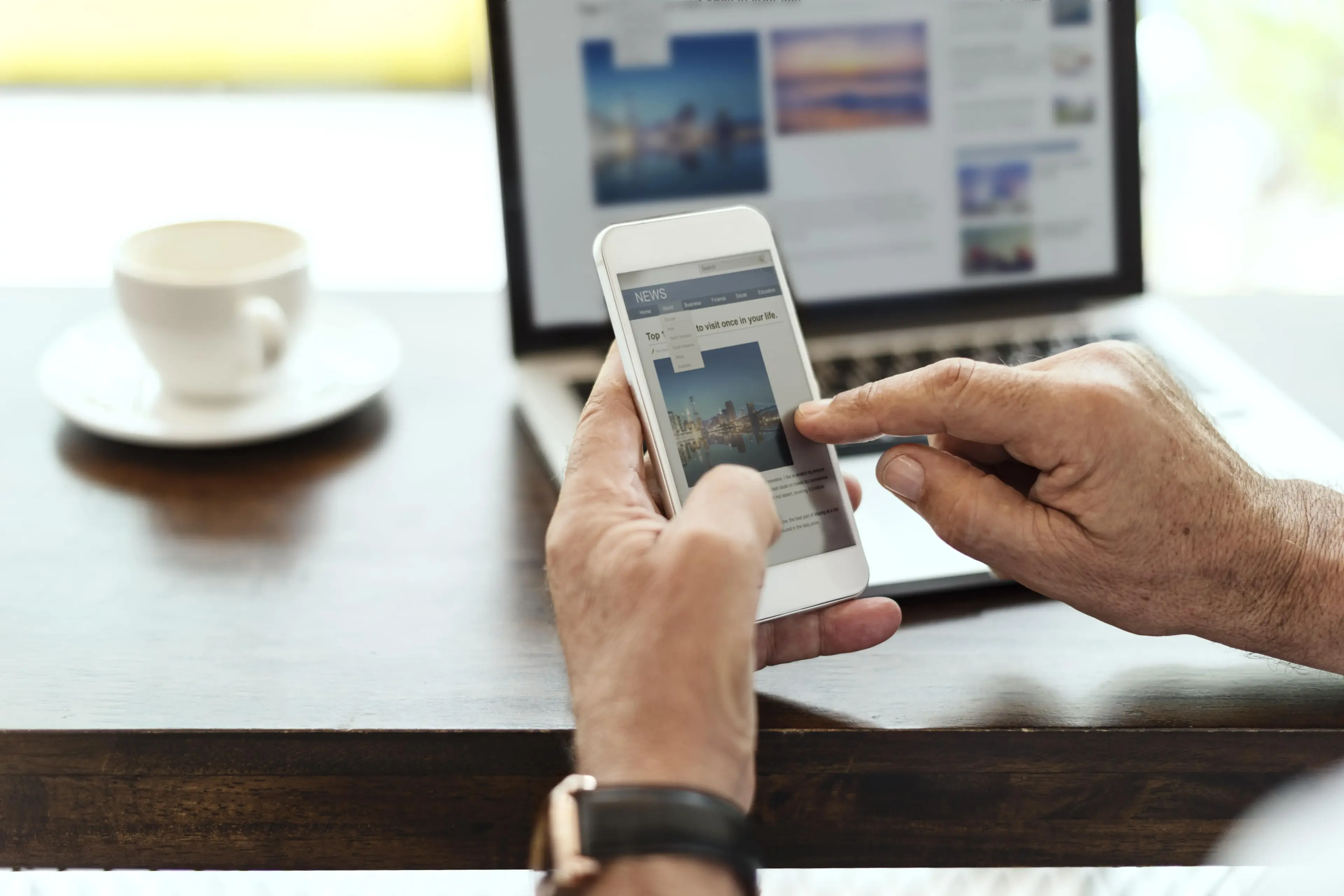Person browsing a website on a smartphone at a desk.